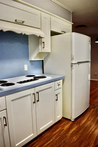 a close view of a refrigerator in kitchen and an empty room
