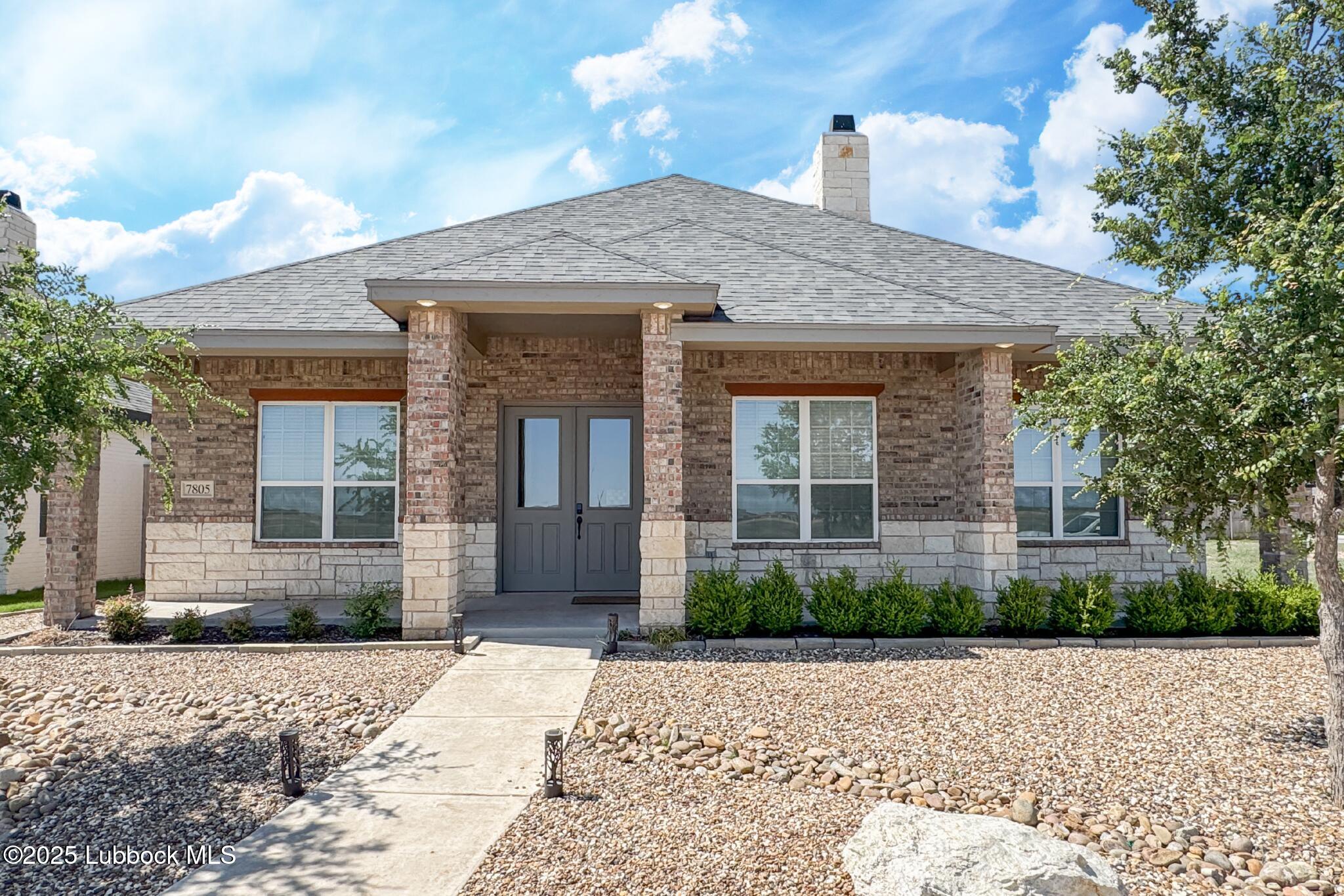 7805 52nd Street Lubbock, TX 79407 - Photo 1 of 32 a front view of a house with a garden