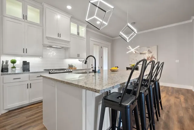 a kitchen with stainless steel appliances granite countertop a sink a stove and a refrigerator