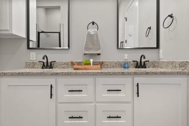 a bathroom with double sink and two mirror