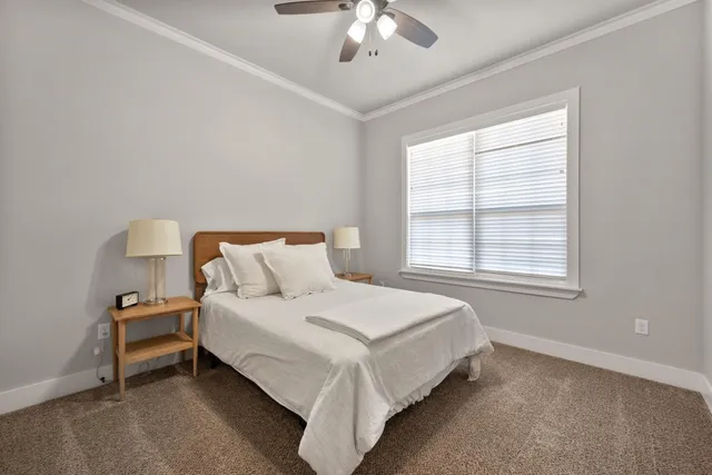 a large bed sitting in a bedroom next to a window and a chandelier