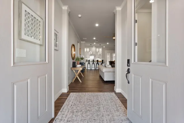 a view of a hallway with a dining table and chairs