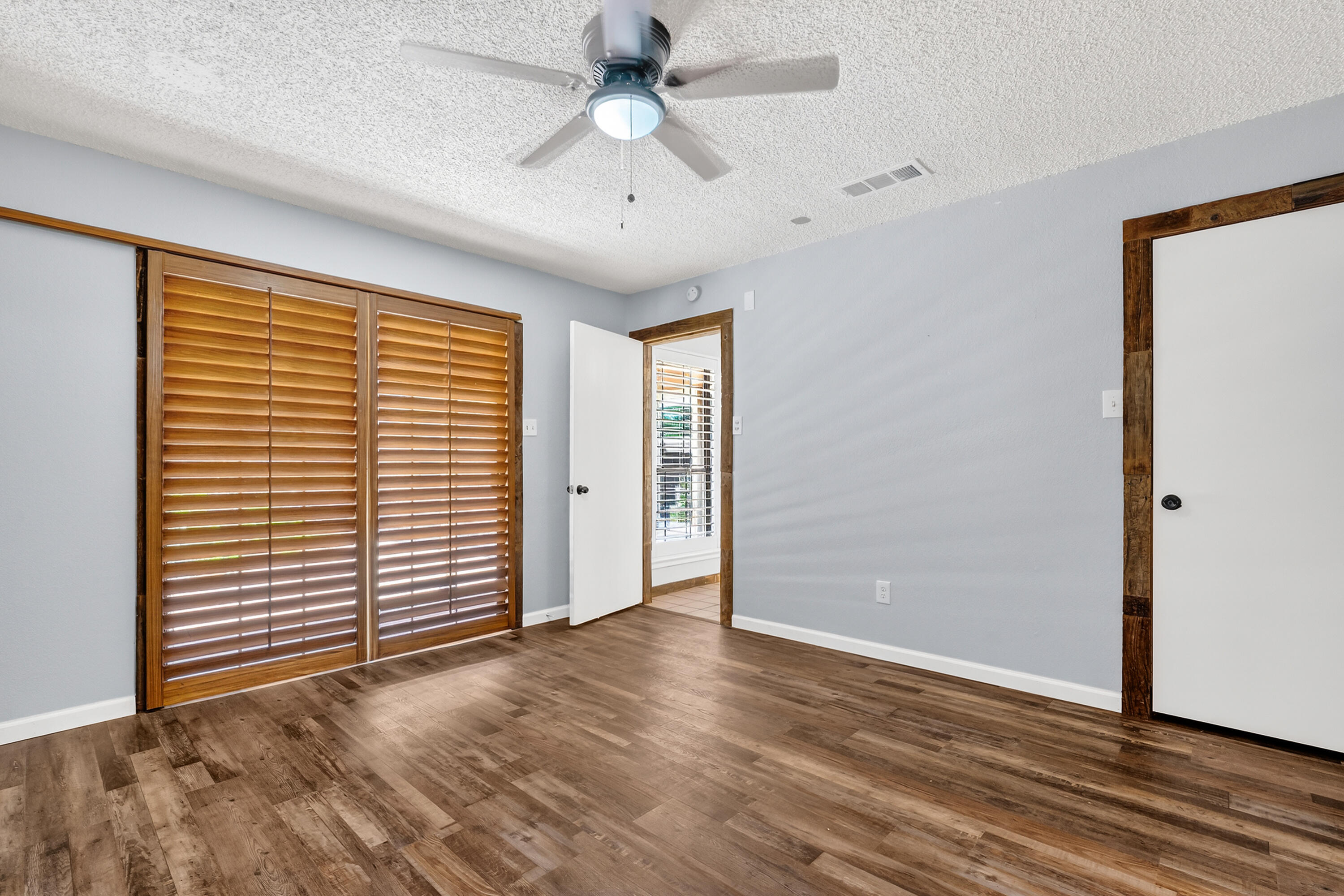 5236 91st Street Lubbock, TX 79424 - Photo 12 of 23 an empty room with wooden floor chandelier fan and windows