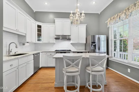 a kitchen with stainless steel appliances a sink stove and table