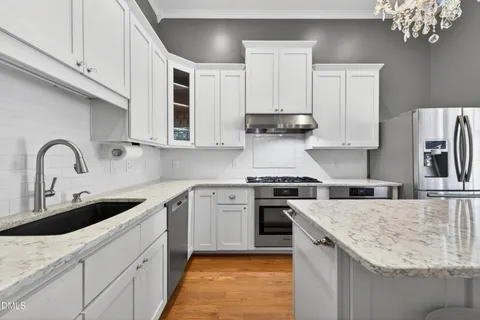 a kitchen with stainless steel appliances granite countertop a sink stove and cabinets