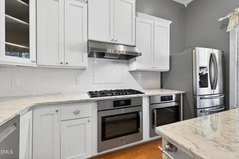 a kitchen with stainless steel appliances granite countertop a stove a refrigerator and a microwave