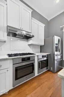 a kitchen with stainless steel appliances granite countertop a stove and a refrigerator
