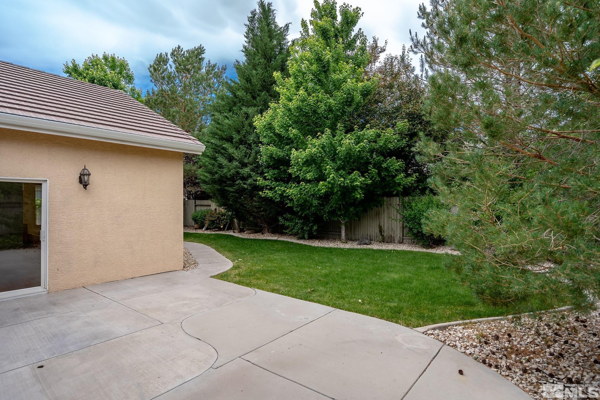 1575 Sutterbrook Way Reno, NV 89521 - Photo 20 of 21 a backyard of a house with plants and large tree