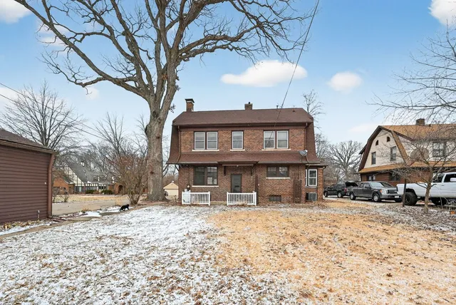 a view of a house with a yard covered in snow