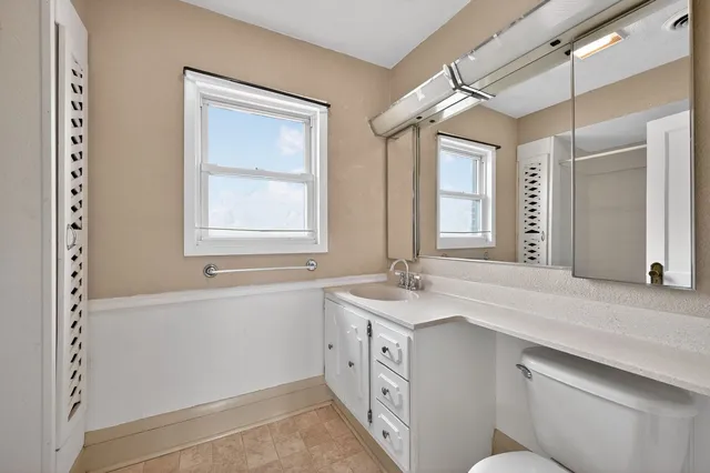 a spacious bathroom with a granite countertop sink mirror and a bathtub