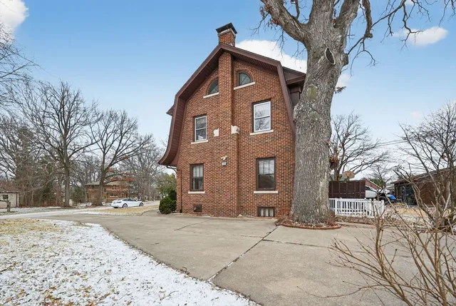 a front view of a house with a yard covered in snow