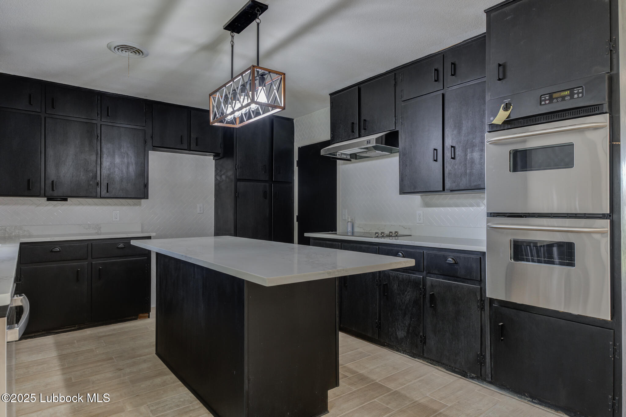 2803 West 18th Plainview, TX 79072 - Photo 12 of 32 a kitchen with stainless steel appliances granite countertop a sink stove and refrigerator