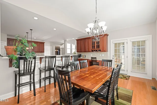 a kitchen with stainless steel appliances kitchen island granite countertop a dining table chairs and refrigerator
