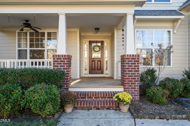 a front view of a house with a yard and potted plants