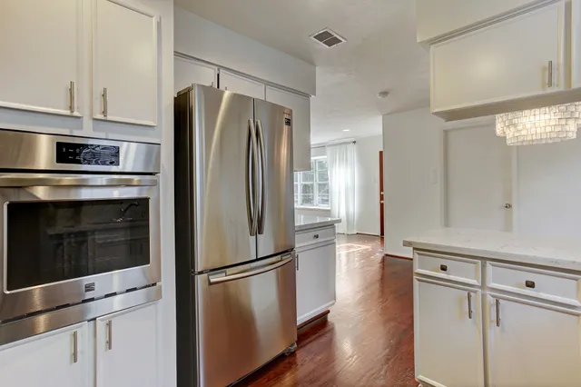 a kitchen with stainless steel appliances a refrigerator stove and cabinets