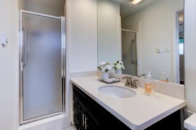 an empty room with wooden floor chandelier fan and windows