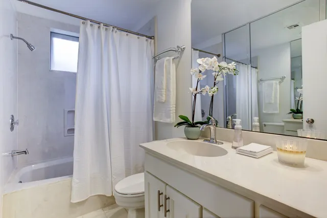 an empty room with wooden floor chandelier fan and windows