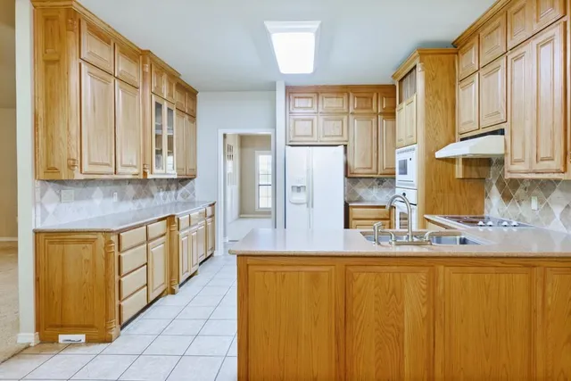 a kitchen with stainless steel appliances granite countertop a refrigerator and a stove top oven
