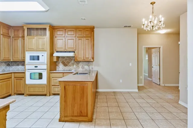 a large kitchen with stainless steel appliances granite countertop a sink and dishwasher a stove with wooden cabinets