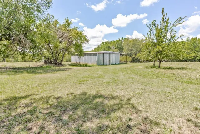 a yellow house with a yard in front of it