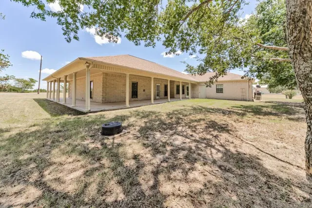 a front view of a house with a yard and trees