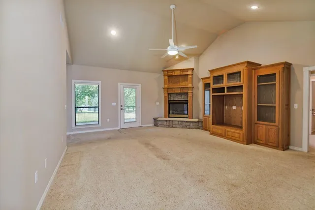 an empty room with fireplace and windows