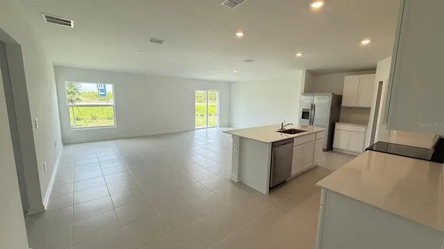 a large kitchen with a window and stainless steel appliances