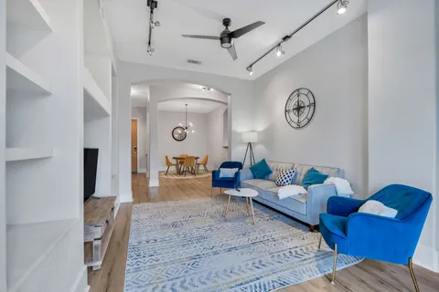 a living room with furniture and a wooden floor