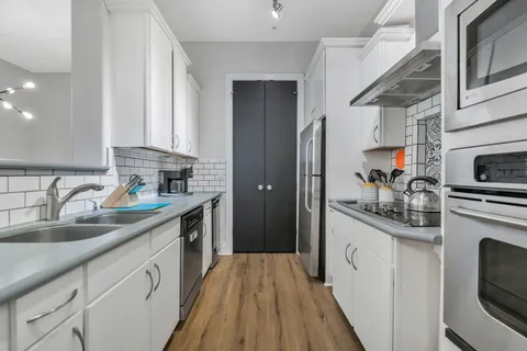 a kitchen with stainless steel appliances granite countertop a sink stove and refrigerator