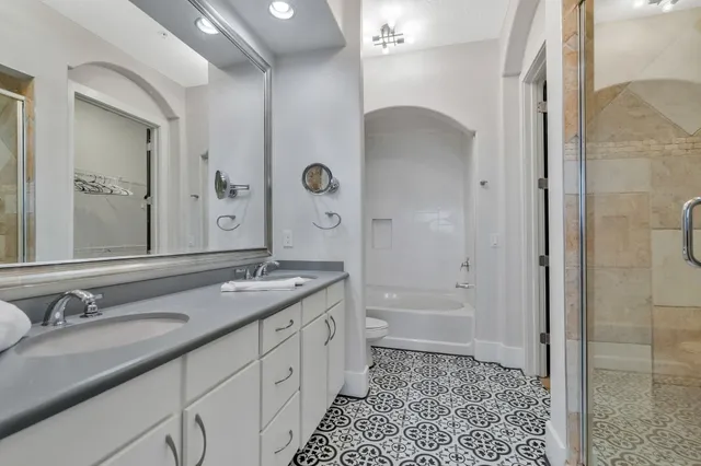 a bathroom with a granite countertop sink a mirror and a shower
