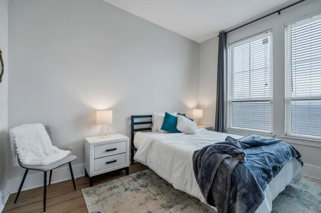 a bedroom with a bed and wooden floor