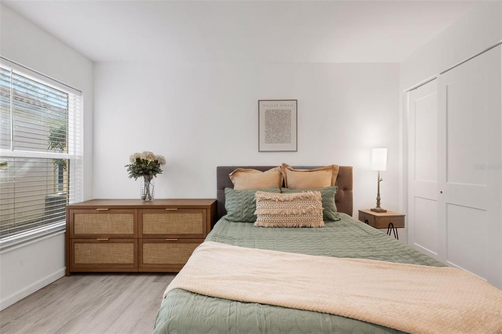 606 Marcus Street, Unit 26 Venice, FL 34285 - Photo 31 of 42 a bedroom with a large bed and a potted plant