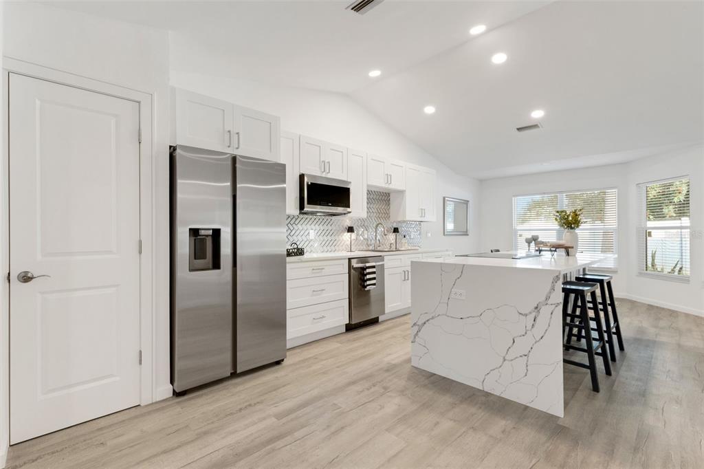 606 Marcus Street, Unit 26 Venice, FL 34285 - Photo 5 of 42 a kitchen with white cabinets and stainless steel appliances