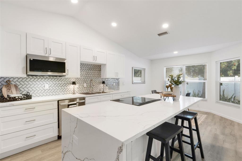 606 Marcus Street, Unit 26 Venice, FL 34285 - Photo 7 of 42 a view of kitchen with white cabinets and chairs