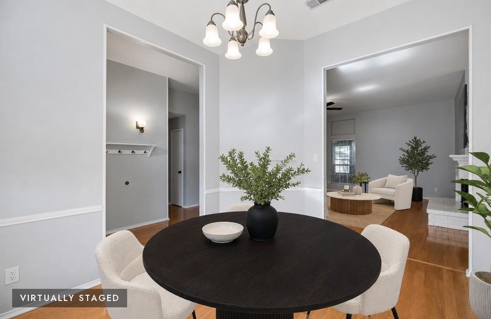 2074 Briarcliff Road Lewisville, TX 75067 - Photo 5 of 40 Dining area with a chandelier, light gray walls, and wood-finish flooring - virtually staged