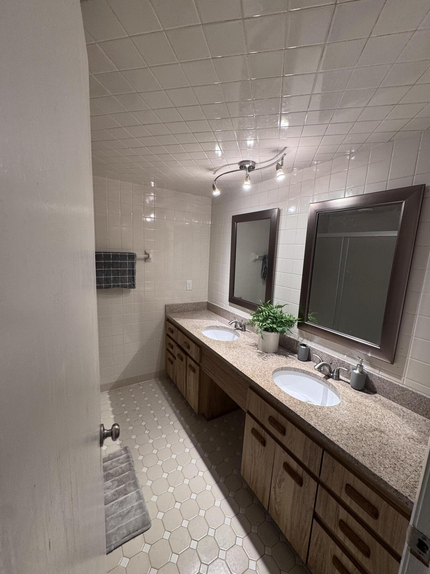 108 Lacosta Lane, Unit 611 Daytona Beach, FL 32114 - Photo 5 of 6 a bathroom with a double vanity sink and a mirror