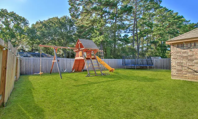 a backyard of a house with childrens swings and slides
