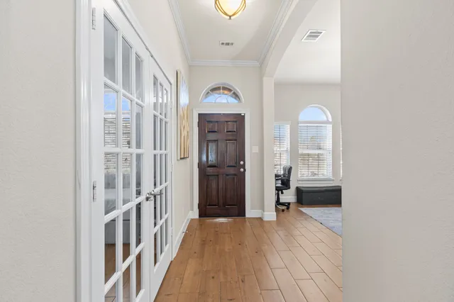 a view of a hallway with wooden floor and entryway