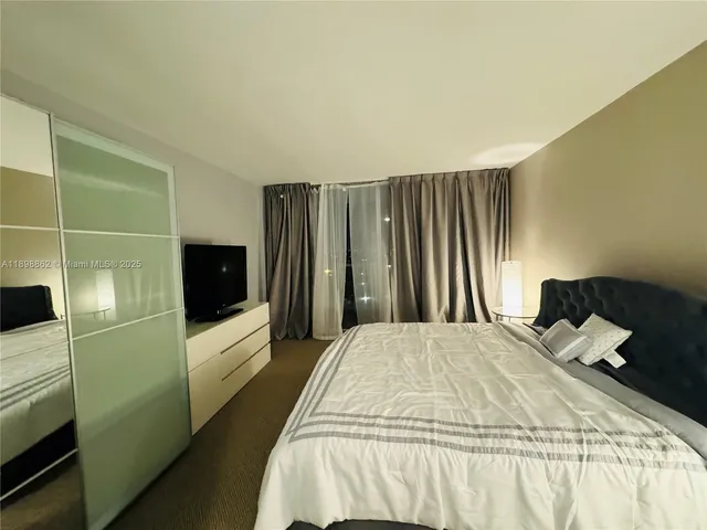 a bedroom with a bed and a television