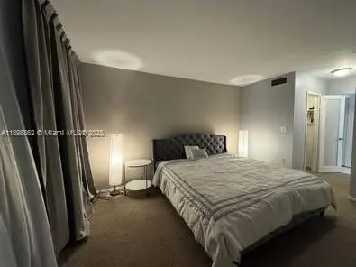 a bedroom with a bed and a refrigerator