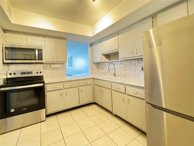 a kitchen with granite countertop cabinets stainless steel appliances and a counter space