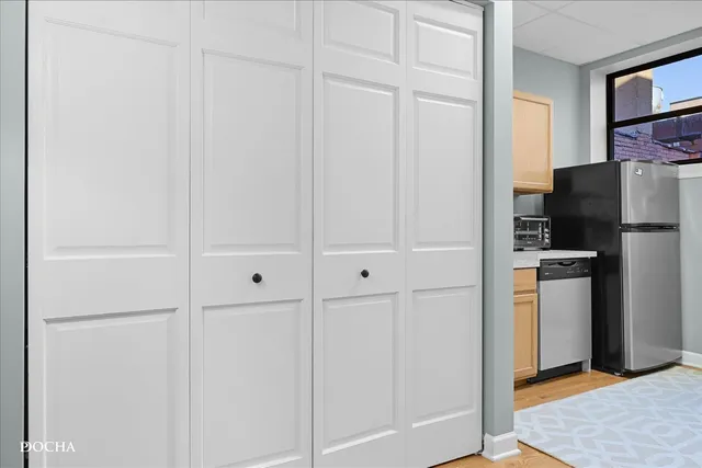 a kitchen with a refrigerator and white cabinets