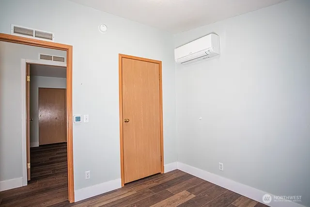 a view of empty room with wooden floor