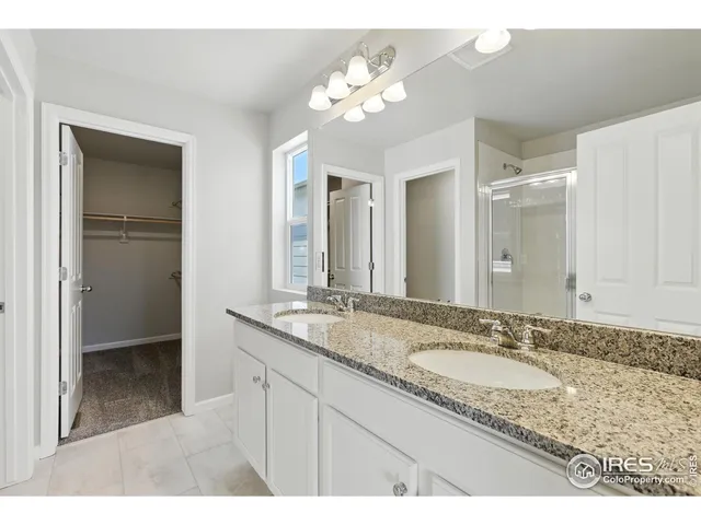a bathroom with a granite countertop sink a large mirror and a shower