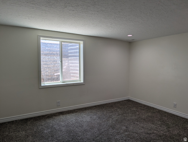 171 South Mustang Road East Grantsville, UT 84029 - Photo 19 of 41 Room featuring a single window, recessed ceiling lighting, textured ceilings, light-colored walls, and gray carpet flooring with white baseboards