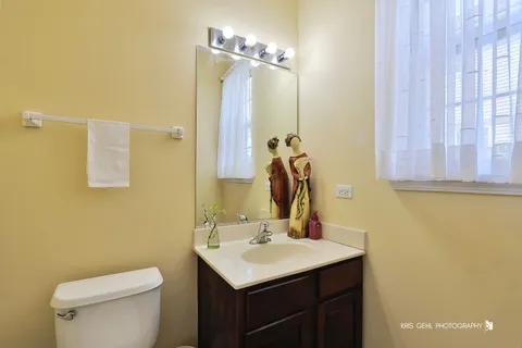 a bathroom with a sink vanity mirror and toilet
