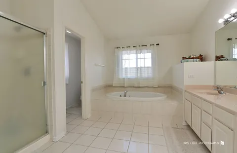 a spacious bathroom with a granite countertop sink a toilet and mirror