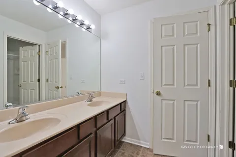 a bathroom with double vanity sinks and a mirror