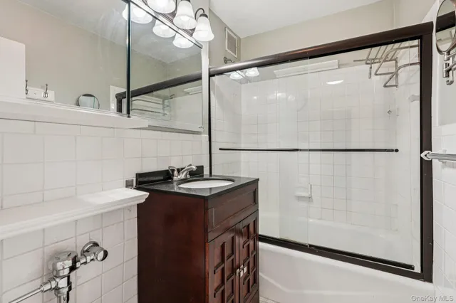 a bathroom with a sink vanity and a shower