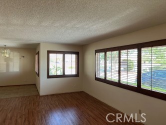 15100 Blackfoot Road Apple Valley, CA 92307 - Photo 11 of 18 an empty room with wooden floor and windows